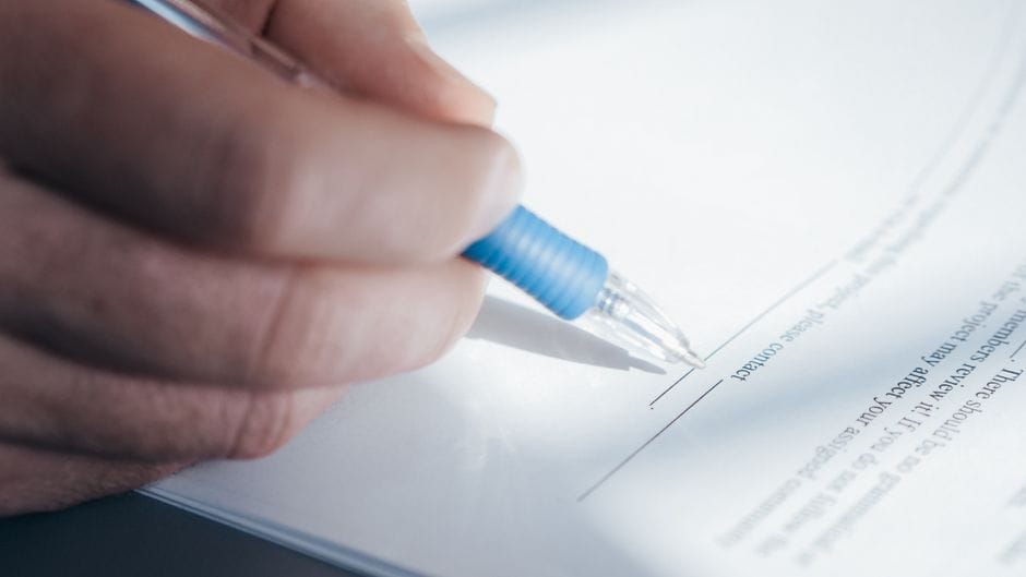 A written tenancy contract being signed, the document Moroccan law requires from the landlord rather than the property manager