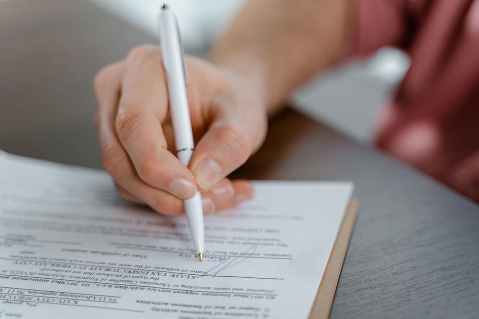 A written lease being signed, the document Moroccan law requires from the landlord rather than the property manager
