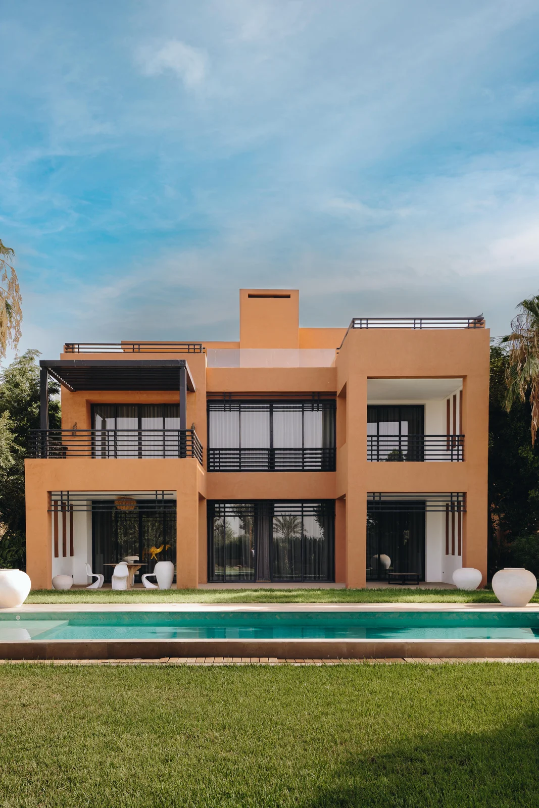 Modern two-storey villa with a pool and palm trees, the kind of Marrakech home that carries property tax in Morocco every year